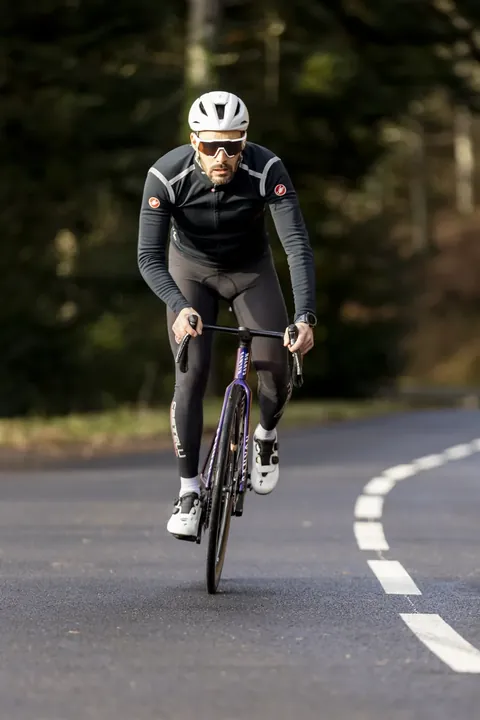 Cycliste à l'entraînement sur une route en forêt